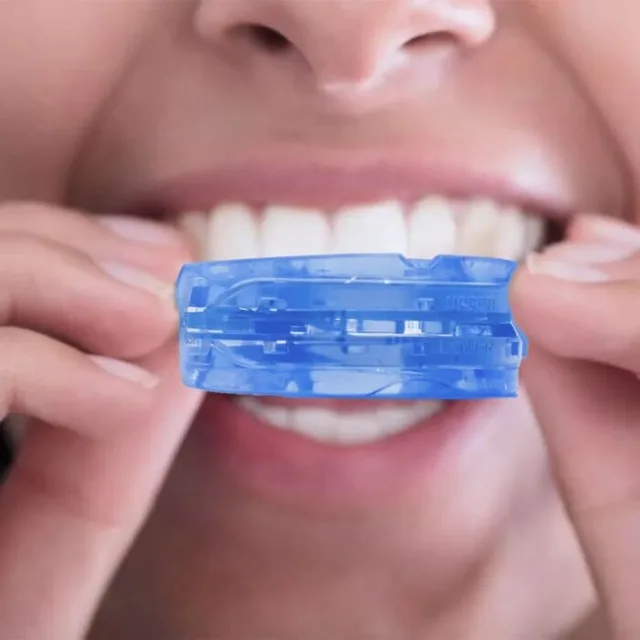 Person holding the molded mouthpiece in front of their teeth, from SleepZee's fitting photos